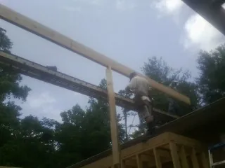 Carpenter setting a ridge beam over a new addition frame — Ice Dam Removal by Roofing Brothers in Silverdale